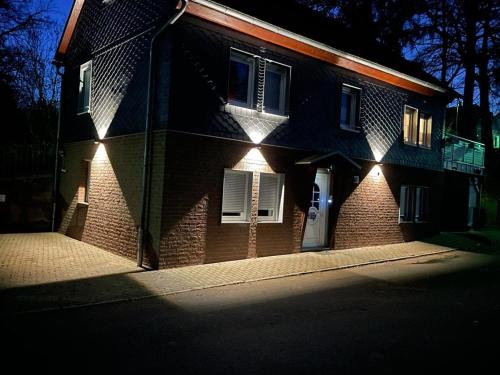 ein Backsteinhaus mit seitlicher Beleuchtung in der Unterkunft Ferienwohnung Engelsbach in Engelsbach