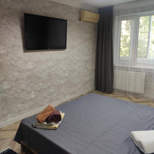 een kamer met een bed en een tv aan de muur bij ВИП квартира in Oral