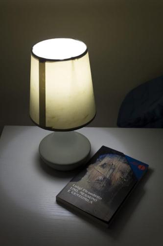a table with a lamp and a book on it at Villa Azzurra Scale of the Turks in Realmonte