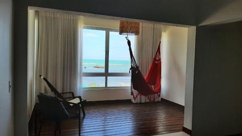 a room with a hammock and a view of the ocean at Pousada Recanto Ha Mar in Maceió