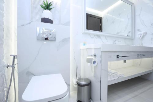 a white bathroom with a sink and a toilet at Bourbon Boutique Hotel in Yerevan
