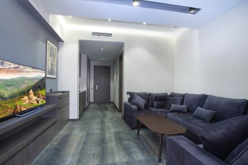 a living room with a couch and a flat screen tv at Bourbon Boutique Hotel in Yerevan