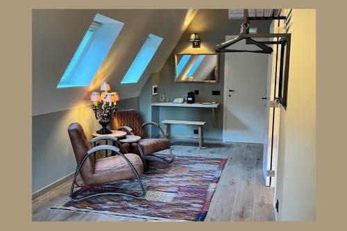 ein Wohnzimmer mit 2 Stühlen, einem Tisch und Oberlichtern in der Unterkunft Letzz Sleep in Brügge