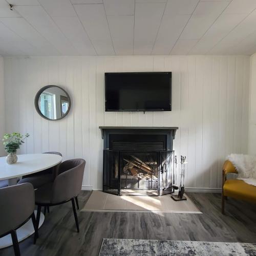 a living room with a fireplace with a tv above it at Muskoka Waterfront Retreat in Dwight