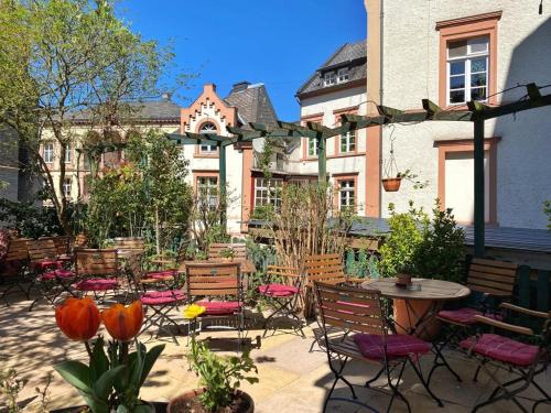 a patio with chairs and tables and a building at Augusta Trarbach in Traben-Trarbach