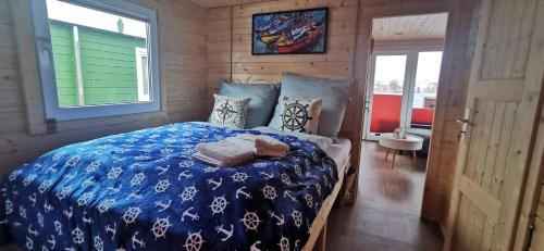 a bedroom with a bed with a blue comforter at Hausboot Wilhelmshaven - Traum Unterkunft an der Jade in Wilhelmshaven