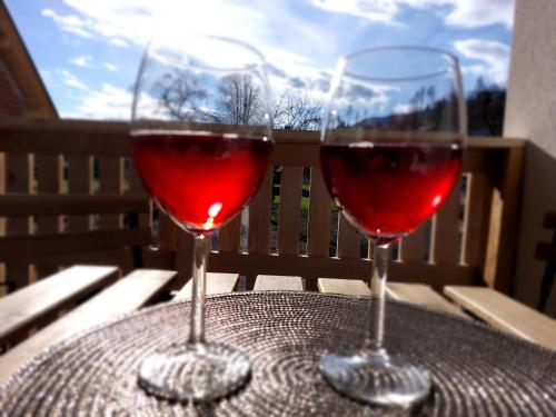 two glasses of red wine sitting on a table at Deluxe Apartments 55 in Kranjska Gora
