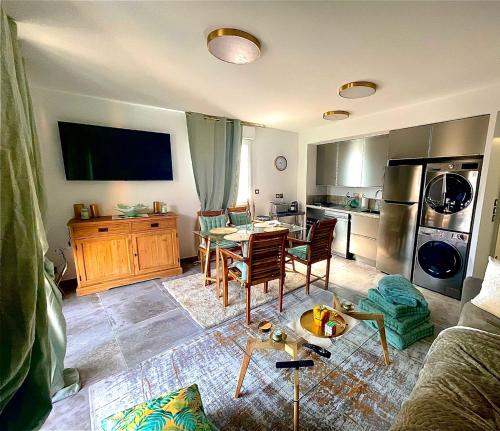 a living room with a table and a kitchen at appartement carqueiranne le port in Carqueiranne