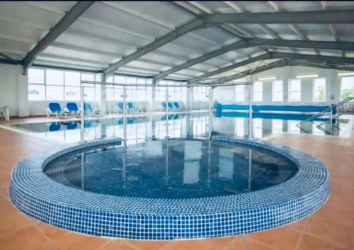 uma piscina com uma grande piscina circular em new Perran holiday resort em Newquay