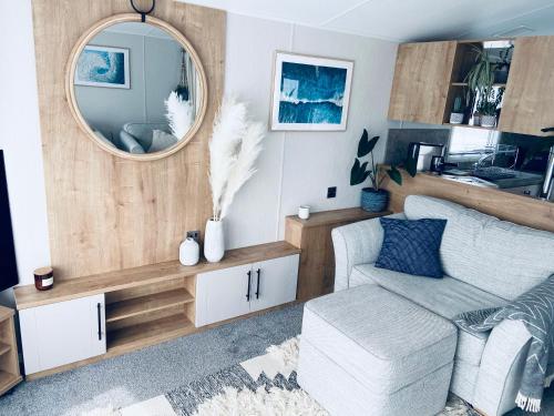 uma sala de estar com um espelho e um sofá em new Perran holiday resort em Newquay