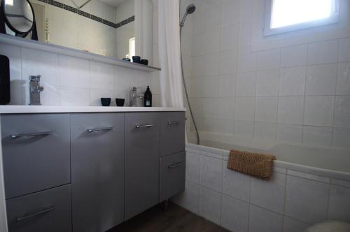 a bathroom with a sink and a bath tub at Maison au cœur du bourg de Creully - 8km de la mer in Creully