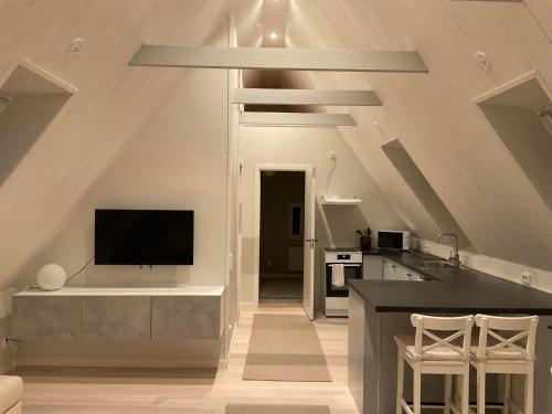 an attic kitchen with a tv and a counter at Högklint by the Sea Apartment in Visby