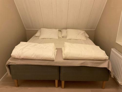 a bed with two white pillows on top of it at Högklint by the Sea Apartment in Visby