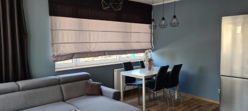a living room with a couch and a table and a window at Apartament Panoramiczna in Kielce