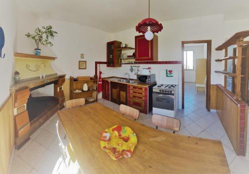 una cucina con tavolo in legno e una sala da pranzo di Cosy home with private parking near by sea a Siniscola