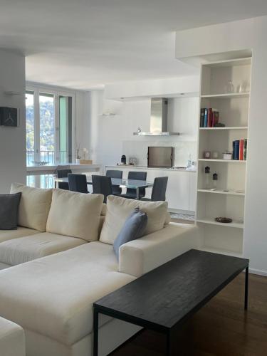 uma sala de estar com um sofá branco e uma mesa em BrixHome em Laveno-Mombello