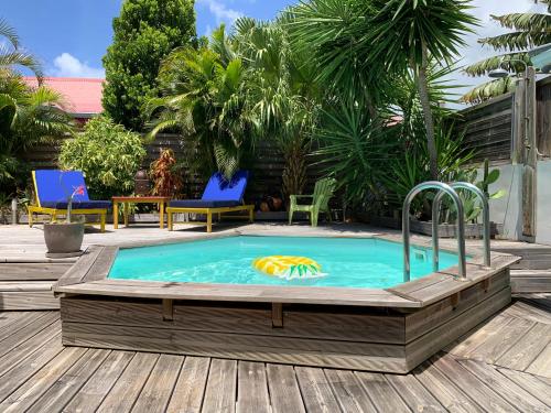 a pool with a hot tub in a wooden deck at Villa Maracoudja in Sainte-Anne