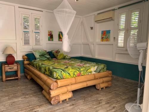 a bedroom with a bed made out of logs at Villa Maracoudja in Sainte-Anne