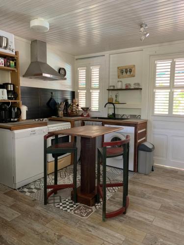 a kitchen with a wooden table and some chairs at Villa Maracoudja in Sainte-Anne