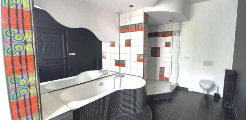 La salle de bains est pourvue d'une baignoire et de toilettes. dans l'établissement Histoire de Loire - DU BELLAY, à Saumur