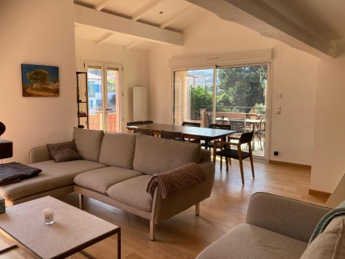un soggiorno con un divano e un tavolo di Villa de charme à 1 minute de la plage à pied a Banyuls-sur-Mer