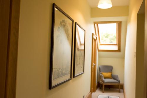 un pasillo con tres cuadros en la pared y una silla en Albion House- Highlands en Lybster