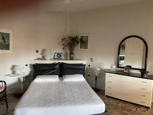 - une chambre avec un grand lit et un miroir dans l'établissement Villa Maurizio, à Rio Marina