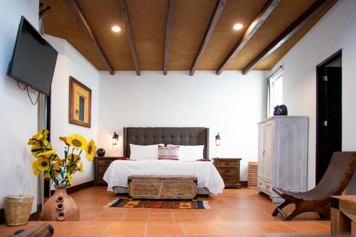 a bedroom with a bed and a tv in a room at Casa de Adobe Gallery & Luxury Boutique in Oaxaca City