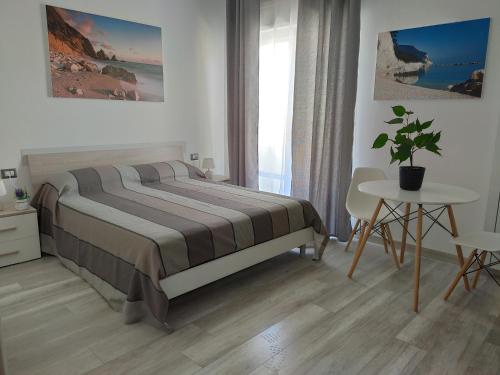 sypialnia z łóżkiem i stołem z doniczką w obiekcie Affittacamere Rosita Recanati w mieście Recanati