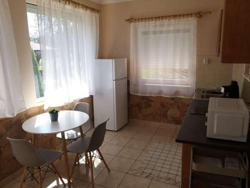 kuchnia ze stołem i białą lodówką w obiekcie Bellis - Apartmanok w mieście Szilvásvárad