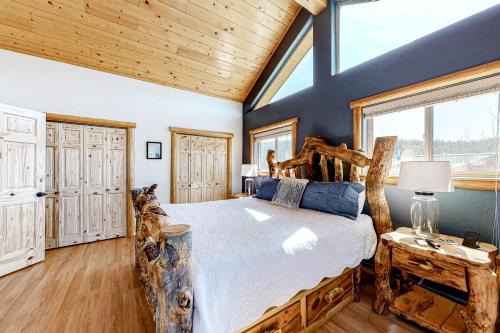 Un dormitorio con una cama grande y un techo de madera. en Riverfront Lodge, en Pagosa Springs