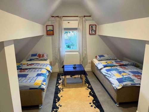 une chambre avec deux lits et une fenêtre dans l'établissement Maison neuve chaleureuse pour 1 à 4 personnes, à Schiltigheim