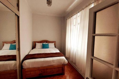 a small bedroom with two beds and a window at Apartamento Entero en Centro de Miraflores - 2 habitaciones in Lima