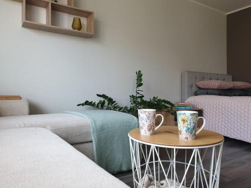 a living room with two mugs on a table at A.H Tammsaare Pärnu Apartment in Pärnu