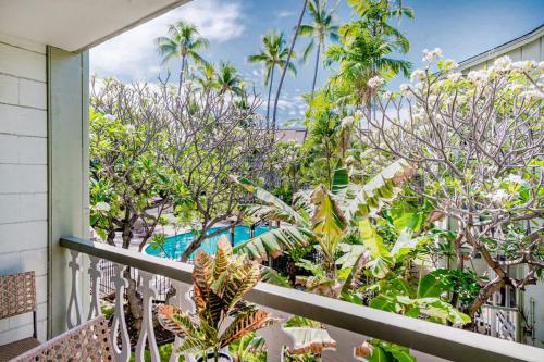 a balcony with trees and a pool in the background at Kona Islander Inn # 219 in Kailua-Kona