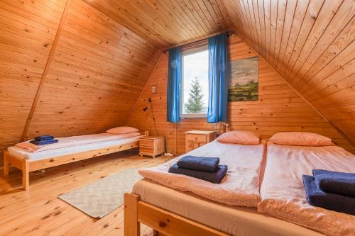um quarto com 2 camas num chalé de madeira em Domek Lesinówka em Cisna