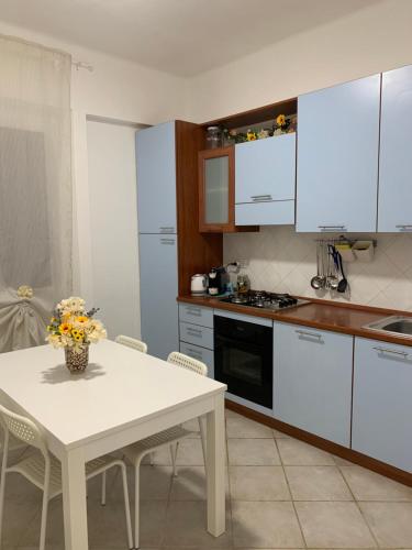 a kitchen with a table and a white table and chairs at Ca' ToscaLina in Carrara