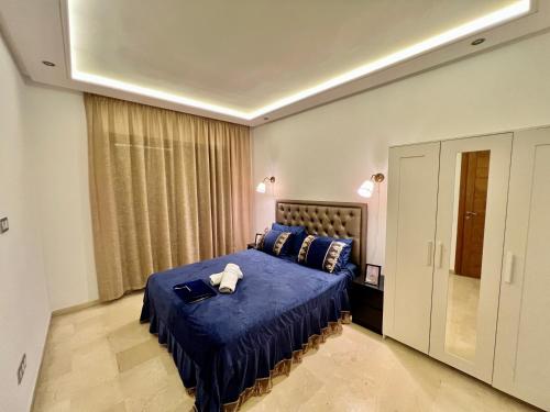 a bedroom with a bed with a blue comforter at luxury studio-Haut standing MAARIF in Casablanca