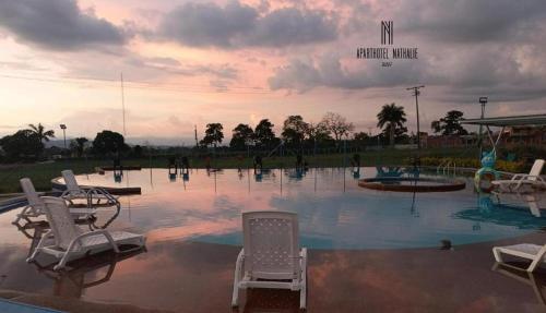 un grupo de sillas sentadas en un charco de agua en ApartHotel Nathalie B207 a 7min Parque del Café, en Montenegro