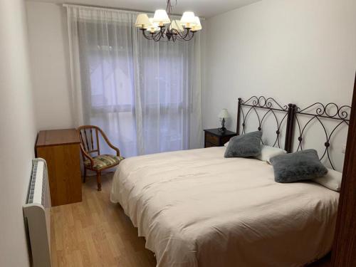 1 dormitorio con 1 cama grande y 2 almohadas en Apartamento Fele con garaje, en Felechosa