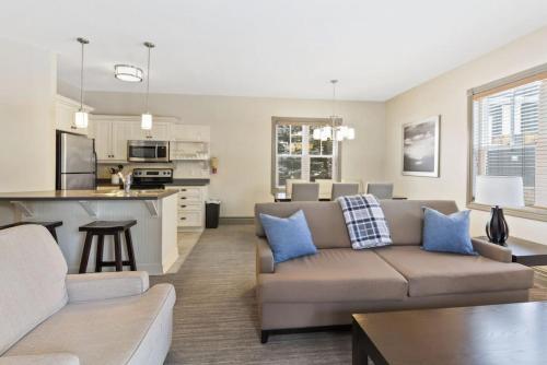 a living room with a couch and a kitchen at Blue Mtn Getaway in Historic Snowbridge Chalet in Collingwood