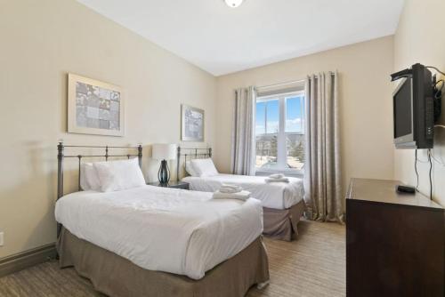 a hotel room with two beds and a flat screen tv at Blue Mtn Getaway in Historic Snowbridge Chalet in Collingwood