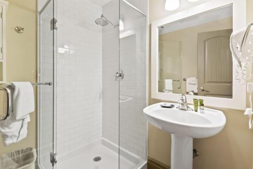a white bathroom with a sink and a shower at Blue Mtn Getaway in Historic Snowbridge Chalet in Collingwood