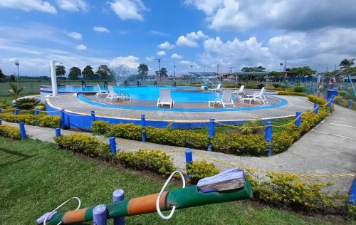 a pool at a water park with two slides at ApartHotel Nathalie B207 a 7min Parque del Café in Montenegro