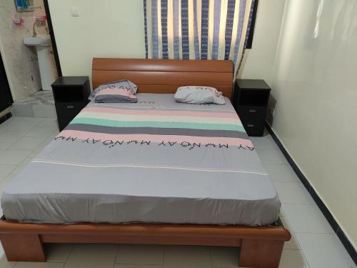 ein Bett mit zwei Kissen auf einem Zimmer in der Unterkunft Gassimmo Avril Location d'appartements in Thiès