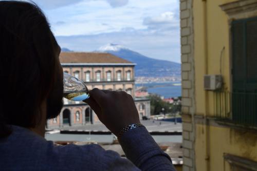 a woman drinking a glass of wine looking out a window at Mecla Suites in Naples