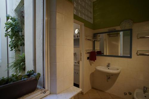 een badkamer met een wastafel en een spiegel bij Appartamento moderno a 2 passi dal Duomo di Parma in Parma