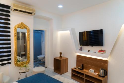 een kamer met een badkamer met een televisie en een spiegel bij The Havana Residence in Istanbul