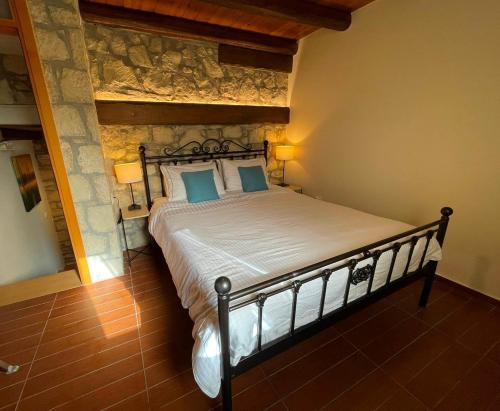 a bedroom with a large bed with blue pillows at Petra Nova Villas in Mochlos