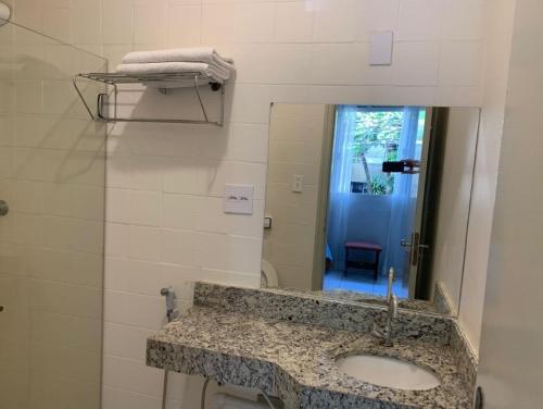 La salle de bains est pourvue d'un lavabo et d'un miroir. dans l'établissement UDIHOSTEL HOSPEDAGEN, à Uberlândia
